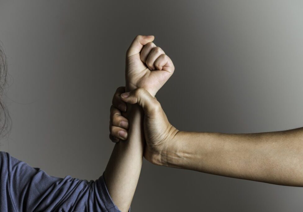 Parent is holding her little girls arm and is about to use violence. Representing child abuse and domestic violence.